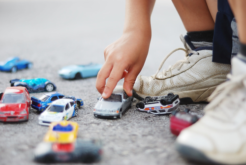 Child playing with toy cars